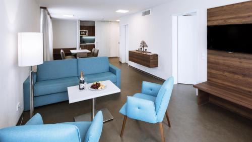 拜罗伊特拜罗伊特首先入住公寓式酒店的客厅配有蓝色家具和桌椅