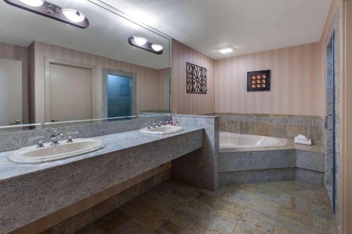 富兰克林Baymont by Wyndham Franklin的浴室设有2个水槽、浴缸和镜子