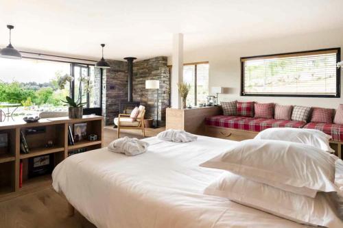 库尔农拉格里兰德斯生态酒店及伊夫黎雪Spa的一间带白色大床的卧室和一间客厅