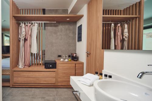 林都斯Lindos Grand Resort & Spa - Adults Only的浴室配有盥洗盆、浴缸和盥洗盆