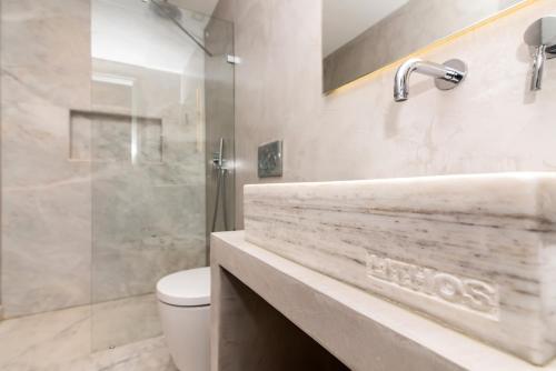 提诺斯Lithos Luxury Suites的一间带水槽、卫生间和淋浴的浴室
