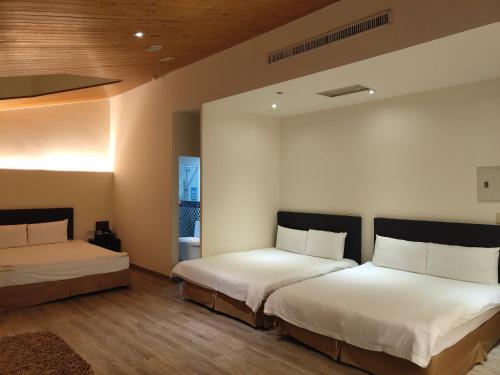 杨梅君洋城堡旅馆的一间卧室配有两张带白色床单的床
