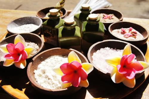 吉利特拉旺安桑巴海滨景观别墅酒店的桌子上放着一碗大米和鲜花