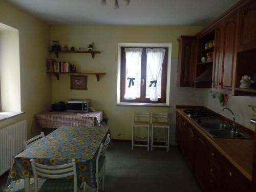法纳诺RIVAROLA的厨房配有桌子、水槽和窗户