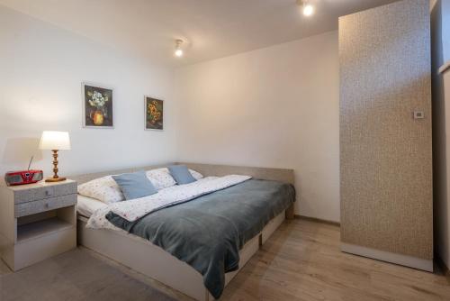 波普拉德Apartment Highway的一间卧室配有一张床和一个带灯的床头柜
