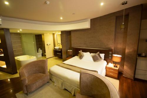 阿鲁沙SG Premium Resort的酒店客房,配有一张床和两把椅子