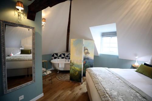 埃佩尔奈Au Jeu de Paume的一间卧室配有一张床、镜子和浴缸