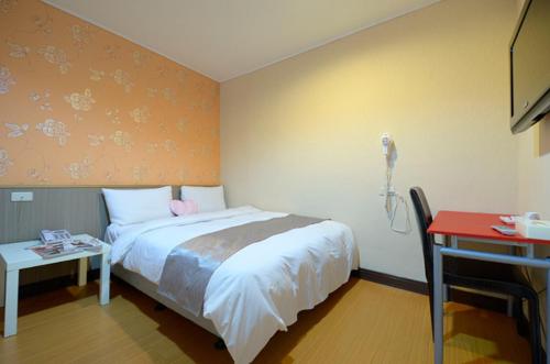 中坜宝山假期旅馆的卧室配有一张床,墙上配有一部电话