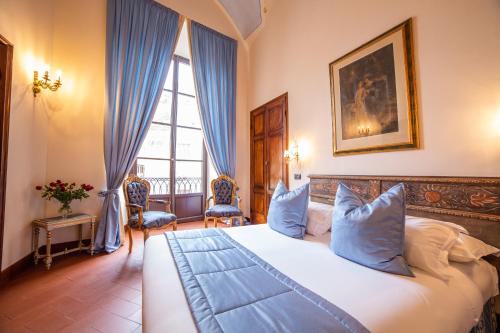 佛罗伦萨伽利略2000住宿加早餐酒店的卧室配有带蓝色枕头的大型白色床