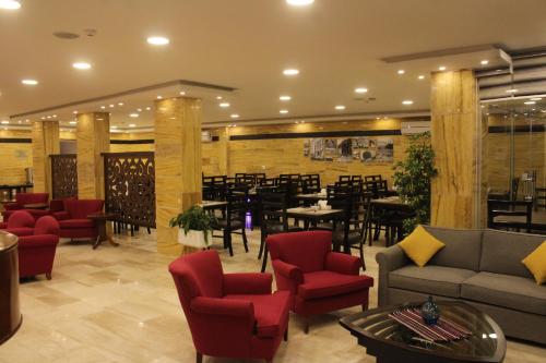瓦迪穆萨Petra Corner Hotel的一间带沙发和桌椅的餐厅