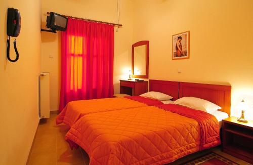 特尔斐赛比拉酒店的一间卧室配有床和红色窗帘
