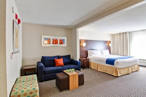 列治文山多伦多万锦智选假日酒店的酒店客房,配有床和蓝色的沙发