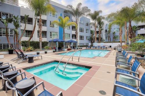 洛杉矶Central Apartment的一个带椅子的游泳池,一个度假胜地