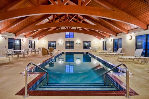 麦迪逊斯塔桥麦迪森套房-东酒店的一座大型室内游泳池,位于一栋带木制天花板的建筑内
