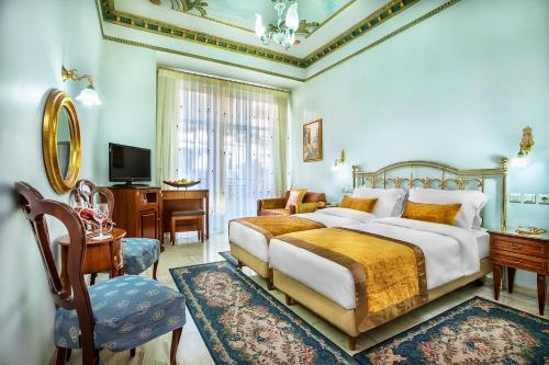 塞萨洛尼基Imperial Palace Classical Hotel Thessaloniki的一间卧室配有一张床、一张书桌和一台电视