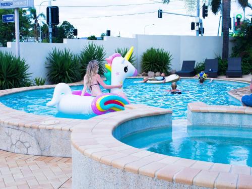 布里斯班Sunnybank Star Hotel的一个小女孩在游泳池里骑着独角兽