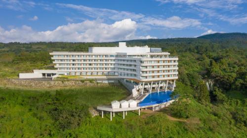 西归浦市大自然隐藏悬崖酒店 的一座大型建筑,前面设有一个游泳池