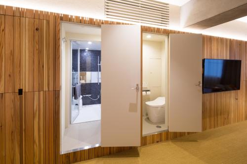 东京Sakura Cross Hotel Tokyo Kayabacho的一间带卫生间的浴室和墙上的电视