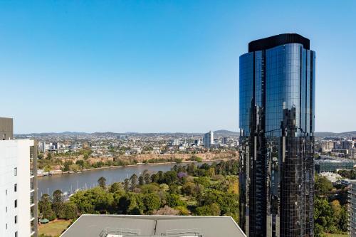 布里斯班Oaks Brisbane River City Suites的 ⁇ 染有河流的高楼