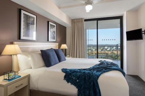 布里斯班iStay River City Brisbane的一间卧室设有一张大床和一个大窗户