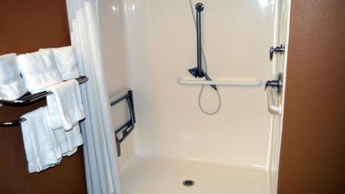 萨福克萨福克智选假日套房酒店的浴室提供白色毛巾和淋浴。