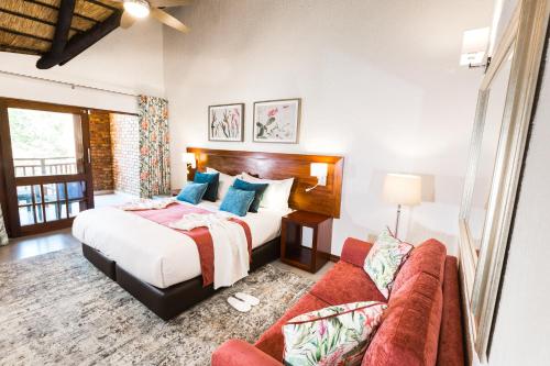 雾观Kruger Park Lodge Unit No. 610B的一间卧室配有一张床和一张沙发