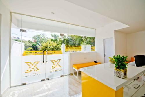 班加罗尔X by Bloom I Hebbal Manyata Park的厨房配有黄色和白色的橱柜和桌子