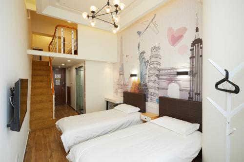 上海上海Meego米果青文酒店的壁画客房内的两张床
