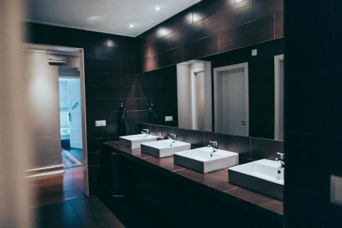 里斯本都市花园旅馆 的一间带三个水槽和大镜子的浴室