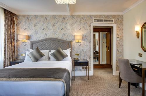 伦敦The Rathbone Hotel, Fitzrovia的酒店客房设有一张大床和一张书桌。