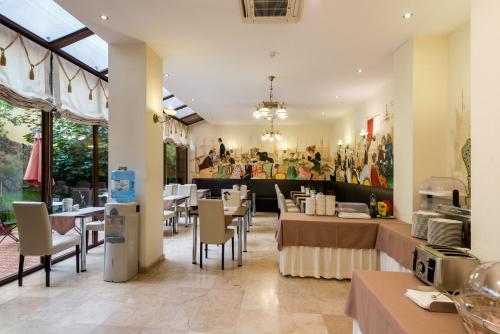 布拉索夫考罗纳布拉索维鲁酒店的用餐室配有桌椅和壁画