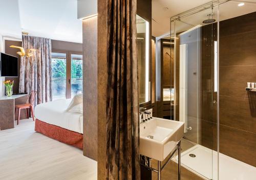 圣塞瓦斯蒂安Axel Hotel San Sebastián - Adults Only的一间带水槽和淋浴的浴室以及一张床