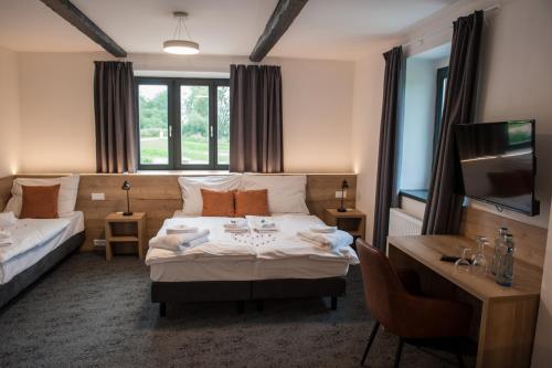 霍尼普拉纳Resort Orsino的酒店客房配有一张床、一张书桌和一台电视。