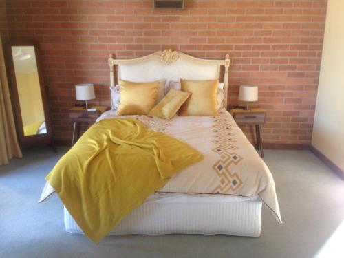 DunollyDunolly Broadway B&B的一间卧室配有一张带黄色床单和枕头的床。