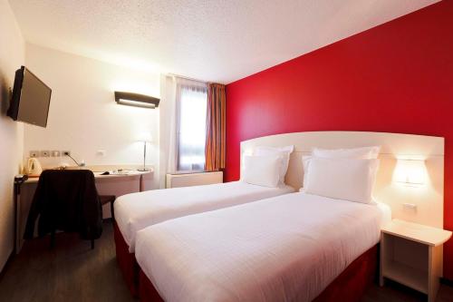 圣热尼拉瓦勒里昂南-圣格尼斯拉瓦尔酒店的酒店客房设有两张床和红色的墙壁。