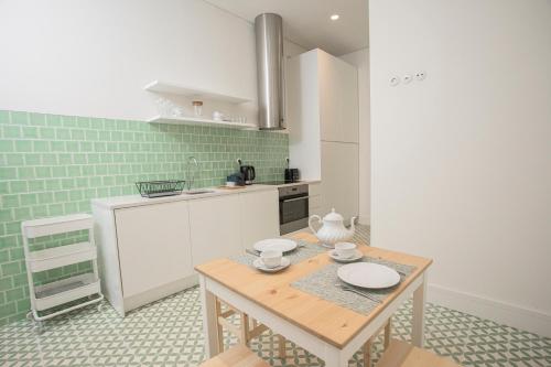 里斯本Montebelo Lisbon Downtown Apartments的一间厨房,内设一张木桌