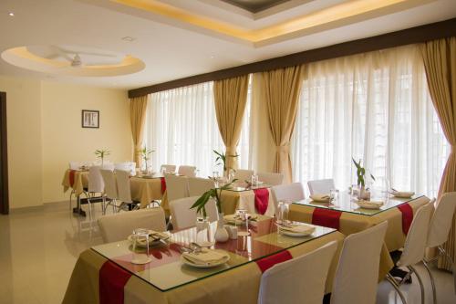 古瓦哈提Hotel Park Riviera的用餐室配有桌椅和窗帘