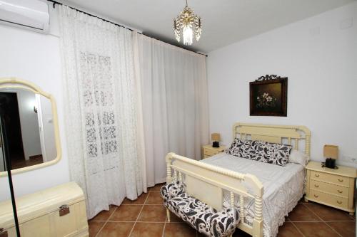 AljucénCasa Rural Mérida的一间卧室配有一张床、一台电视和一面镜子