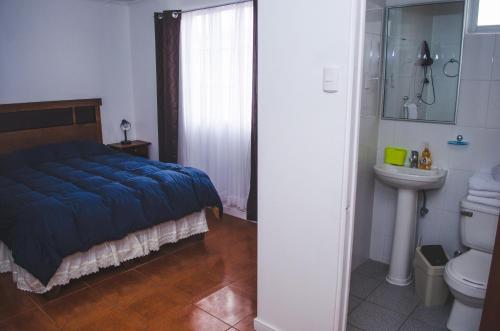 阿里卡Hotel Sol de Arica的一间卧室设有蓝色的床和卫生间