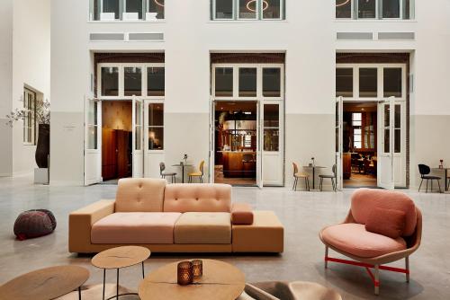 埃因霍温Hotel Mariënhage的客厅配有沙发、椅子和桌子