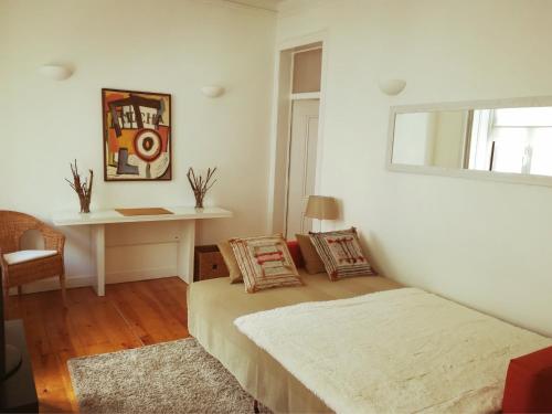 里斯本Lovely Apartment near Belém的白色的客房配有一张床和一张书桌