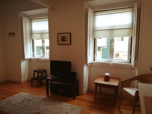 里斯本Lovely Apartment near Belém的客厅设有2扇窗户和1张沙发