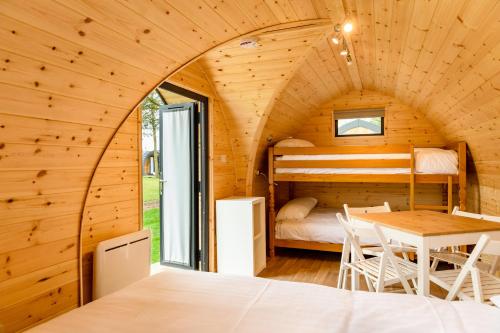 哈里奇Camping Pods, Dovercourt Holiday Park的小屋内带床和桌子的房间