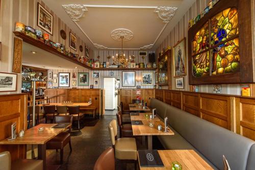 芬洛BnB prins Hendrik Venlo的一间带木桌椅的餐厅和一间酒吧