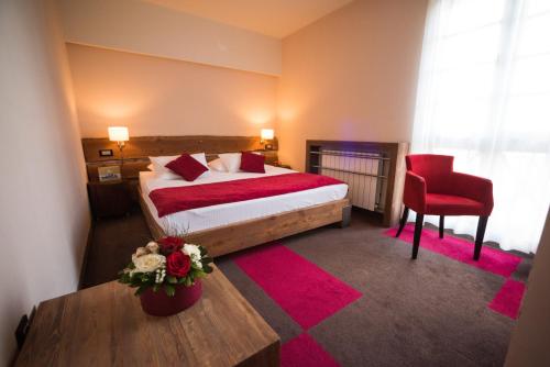 亚霍里纳拉维纳酒店的酒店客房,配有一张床和一张红色椅子