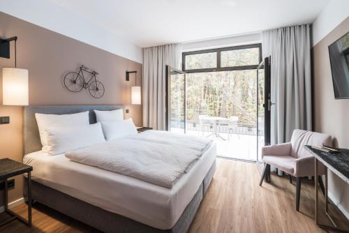 巴特萨罗皮斯库夫Velotel Bad Saarow的一间卧室配有一张床,阳台上的墙上设有自行车