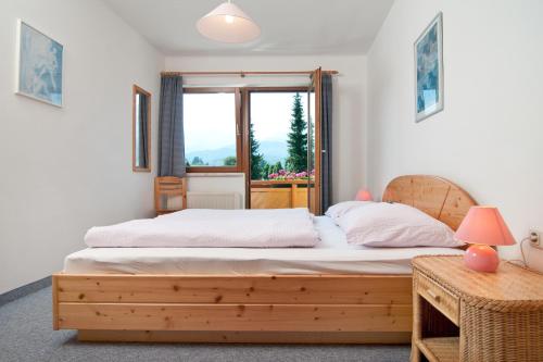 法克湖Haus Christina的一间卧室设有一张木床和一个窗户。
