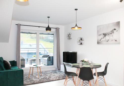 维斯瓦Apartamenty Ski & Fun Spokojna的客厅配有桌子和绿色沙发