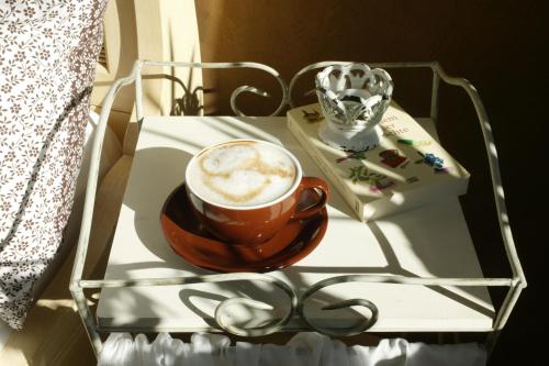 曼德沙伊德Landhotel Pension Haus Sonneck的一杯咖啡在白色的桌子上喝杯,喝杯咖啡
