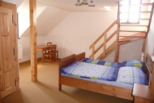 Chmelovice克梅尔维奇农场旅馆的一间卧室设有双层床和楼梯。